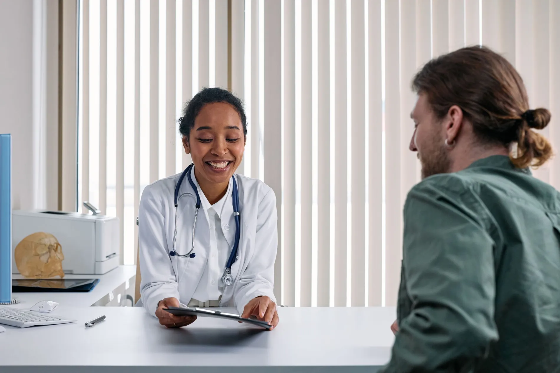 Médica conversando con un paciente en su consulta